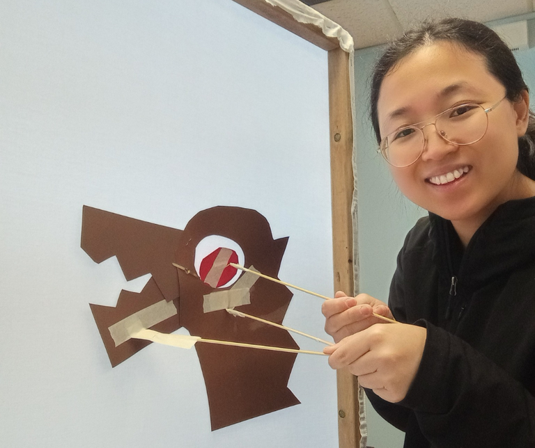 Cherie demonstrating a shadow puppet that she created.