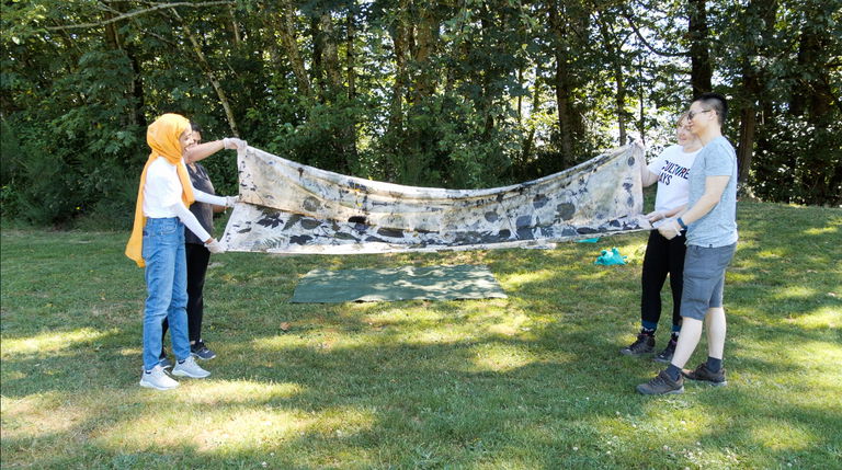 Film still from Into Nature. Emilie shows participants of her Abbotsford hike processes of ecoprinting.