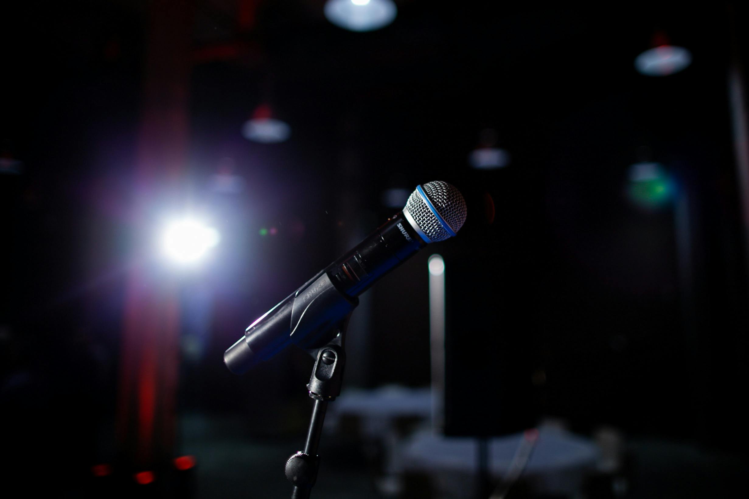 A microphone with a bright back stage light shining. 