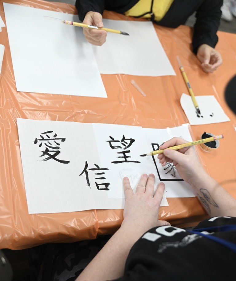 Learning calligraphy with CK Jam Ng. Photo courtesy of the City of Morden.