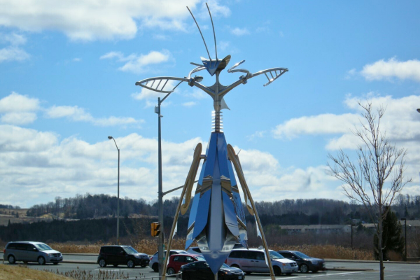 Large metal sculpture of a praying mantis