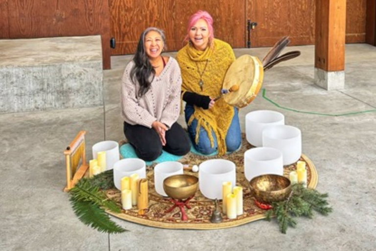 Two women sitting with bowls on a rug
