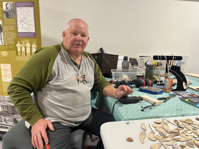 Image of Gary sitting at table, with tools and antler pieces.
