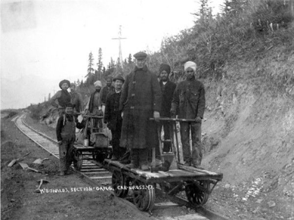 A group of men pose for a picture on a rail car.