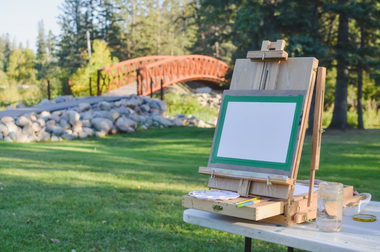 A table easel is set up in front of one of the Little Red River Park bridges