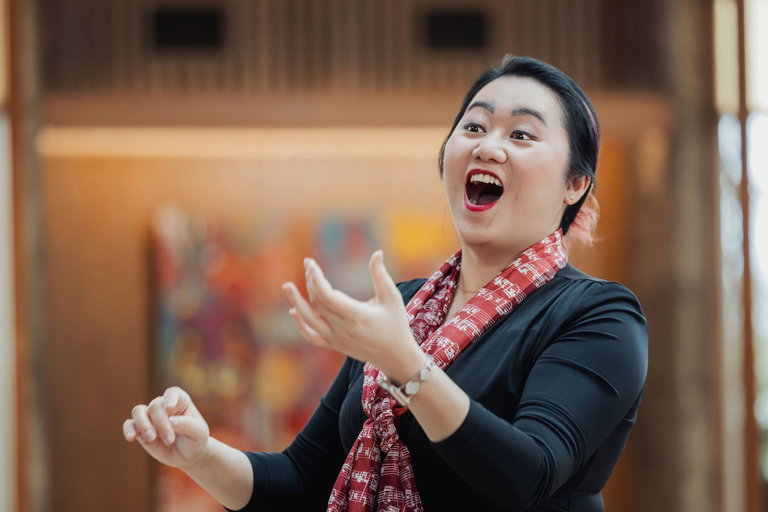 A smiling conductor leads a choir
