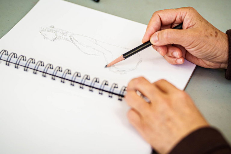 A picture of a woman's hands drawing a person