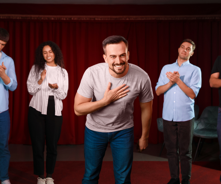 People bowing on stage and clapping