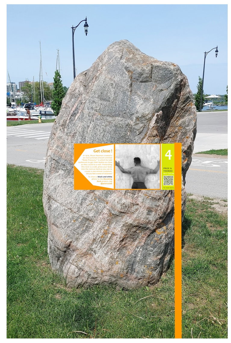 a picture of an instructional sign placed in front of a rock in which participants are encouraged to get close to the large rock