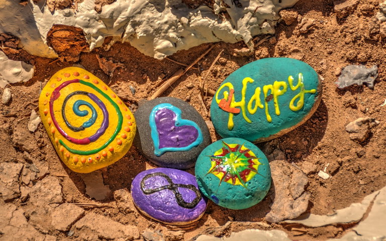 five rocks painted with designs