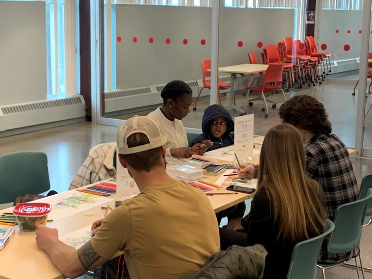 All ages at a workshop table adding colour to Obi's frame design
