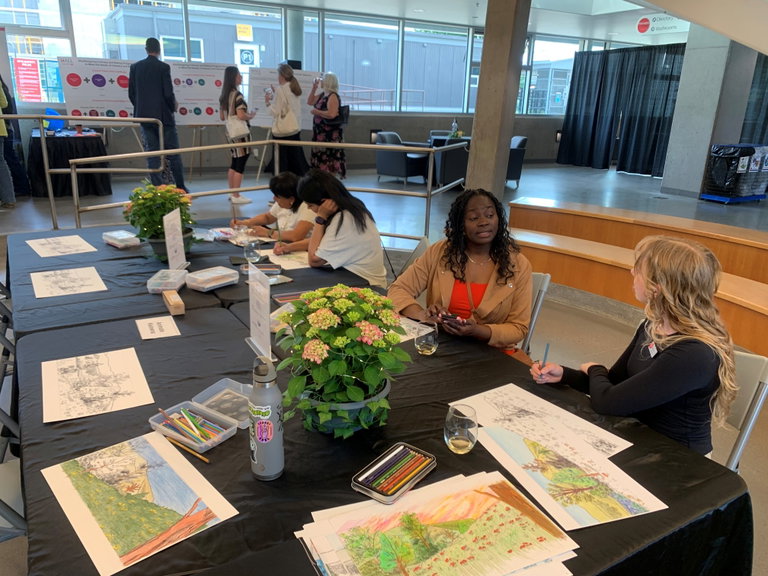 Adults colouring in frames at an indoor table at an event