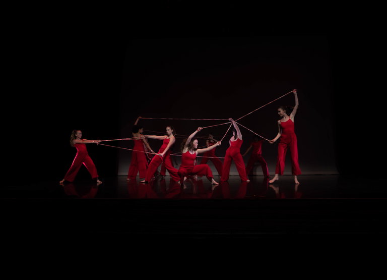a group of women in red dancing on a stage