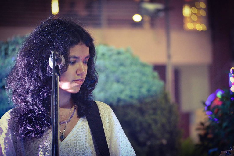 Person standing at a microphone stand.