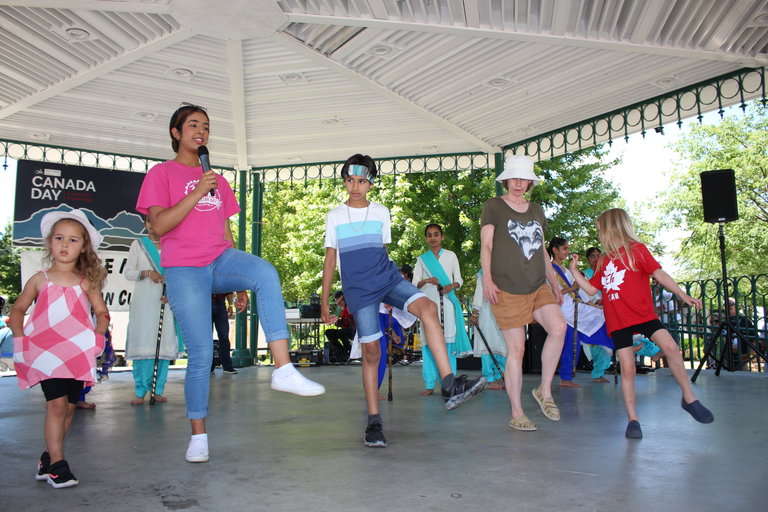 Instructor teaching Bhangra steps to participants in a community workshop.