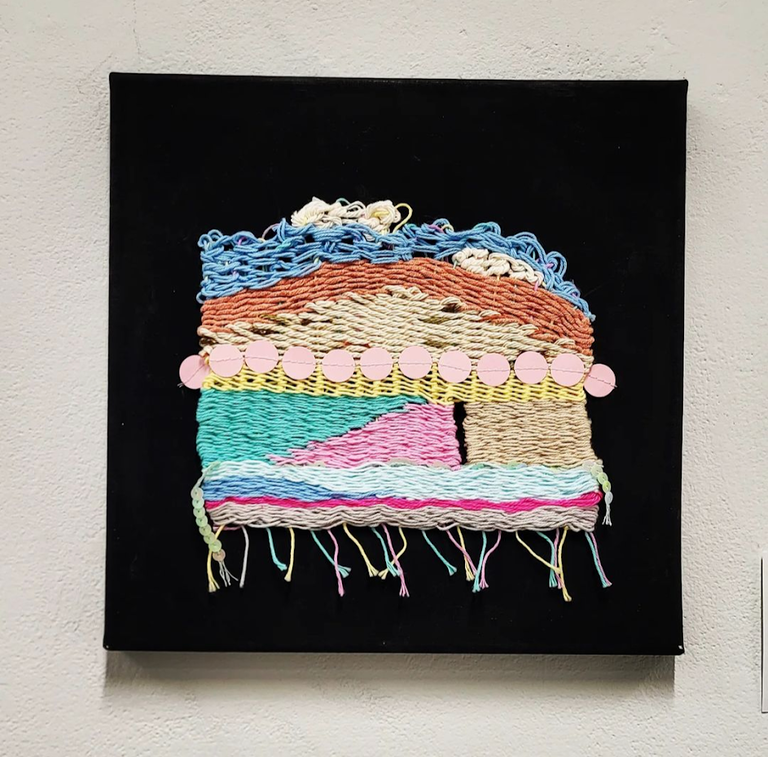 An artwork of woven layers of color against a black background