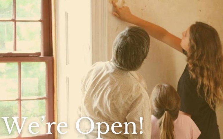 A family pointing at old wallpaper in the John Brown House.