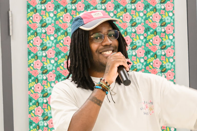 Black man smiling holding a microphone