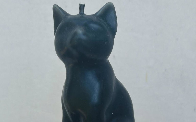 Image of a black cat candle made of beeswax, with a sculptural effect
