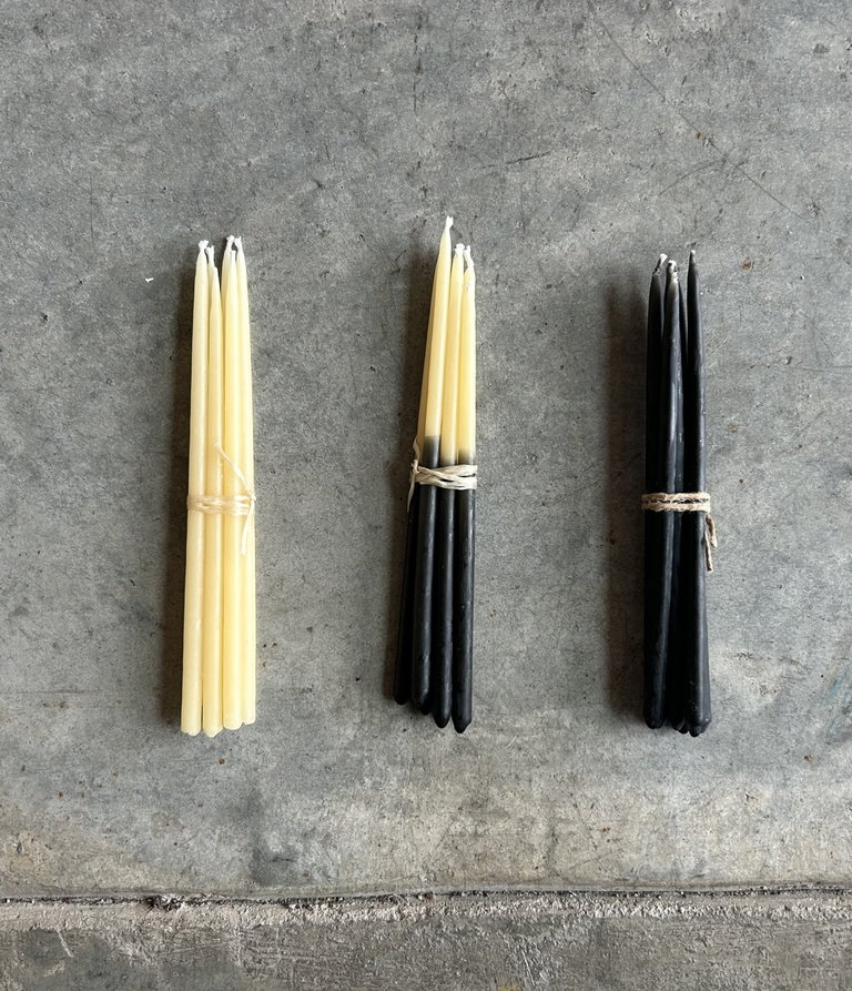 Image of beeswax candle bundles in natural beeswax, half-dipped in charcoal, and full charcoal dipped, reminiscent of porcupine quills