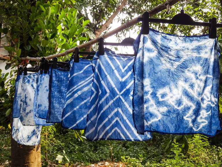 Hanging shibori fabrics in a garden
