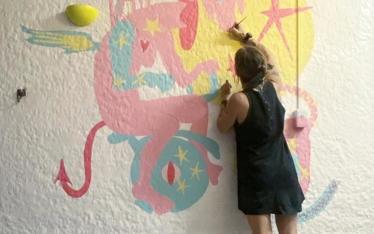 Image of artist Autumn Ducharme painting a mural