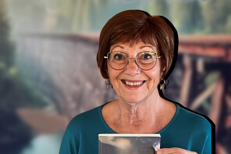 Ruth Chorney smiling wearing a teal shirt and round glasses