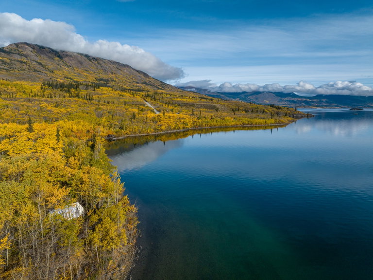 Image of mountain and lake in fall, blue sky with clouds
