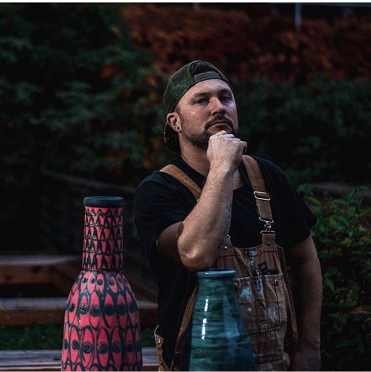 Joe Lyons pictured behind two ceramic vases