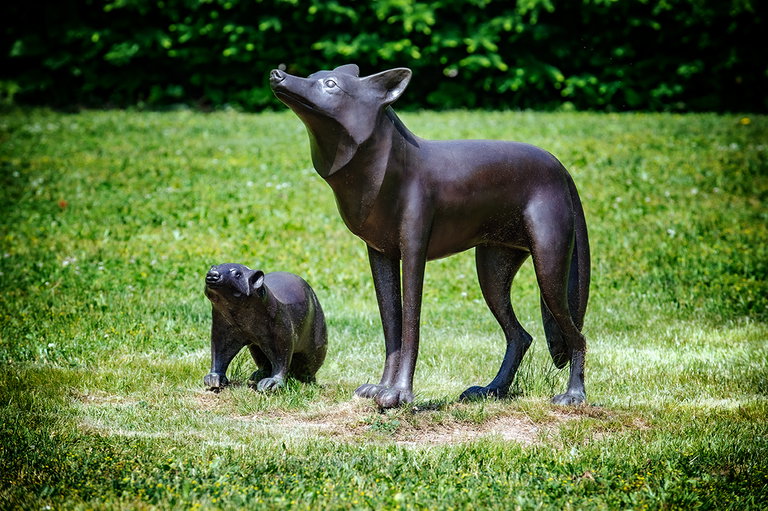 Sculpture of two animals in a grassy field