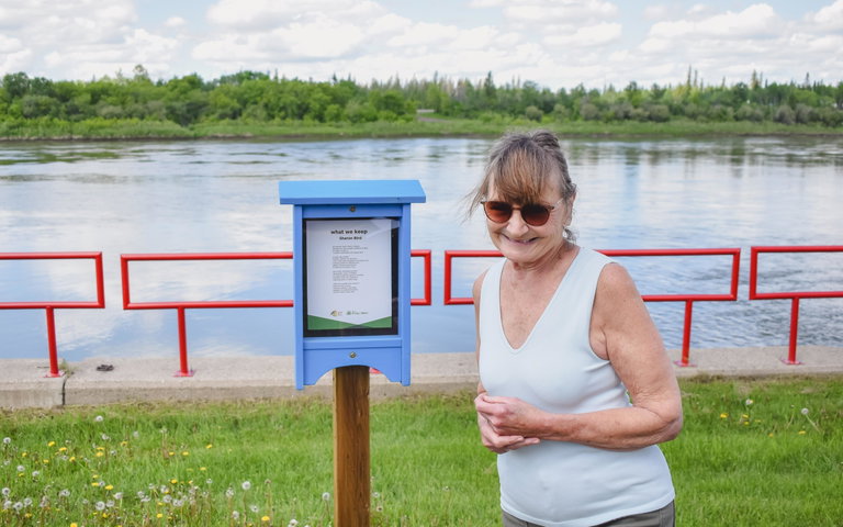 Lynda Monahan smiles in front of a Poetry Box