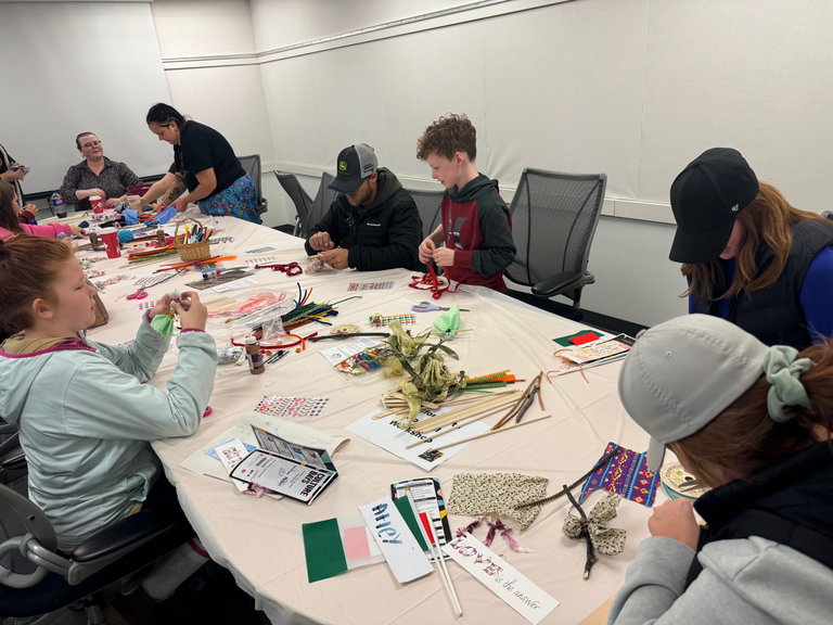 People around a table working on a craft