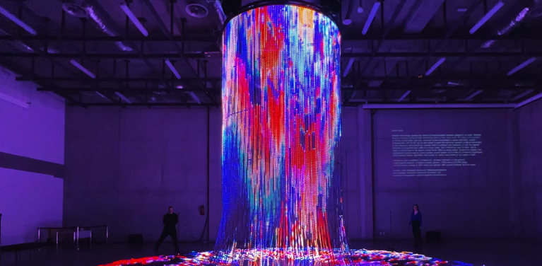 glowing LED light installation with various colours cascading from ceiling to floor.