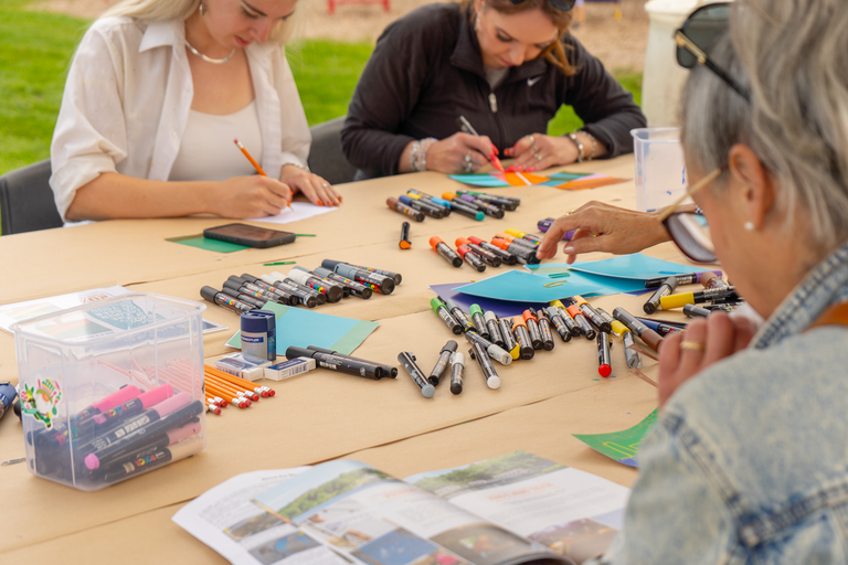 People painting mural tiles and an outdoor table