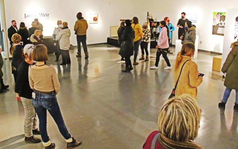 A large, open space in the Weyburn Art Gallery.  Lots of people visiting and having fun.
