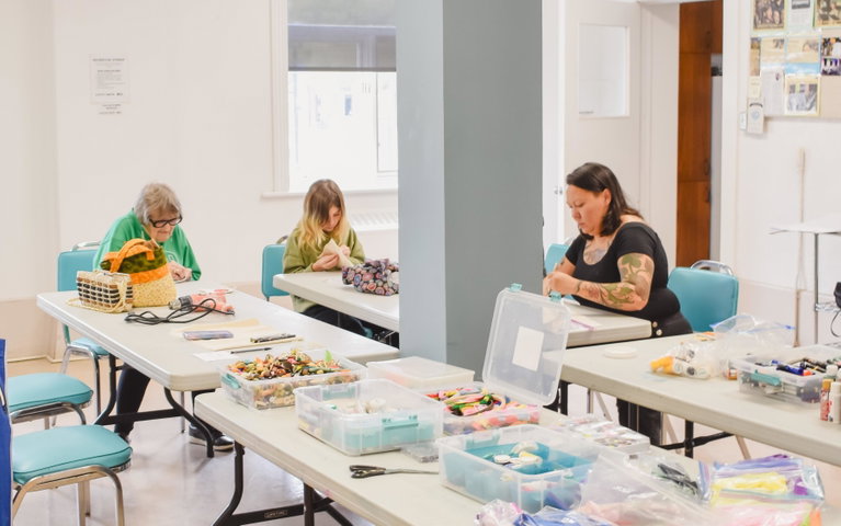 A wide shot of participants making art in the Heritage Room at the Margo Fournier Arts Centre