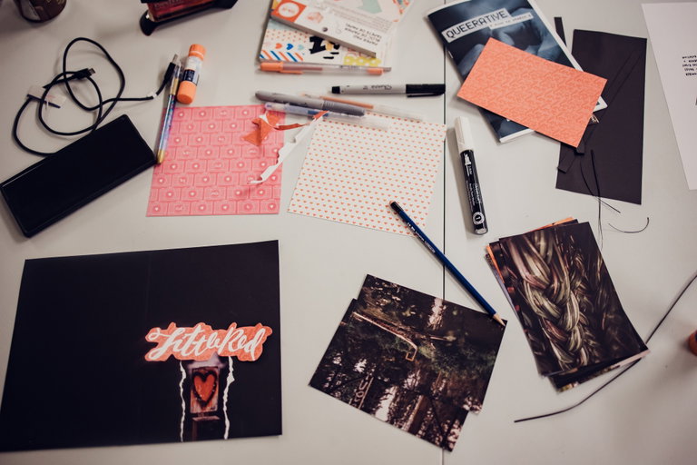 An aerial view of paper, pens, pencils and other art supplies on a table