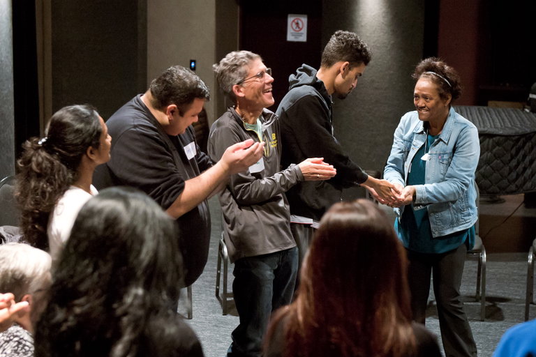 A group of adults participating in a drama game.